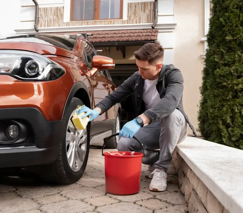 Lavage auto à domicile Bâgé-Dommartin : professionnel intervenant sur un véhicule